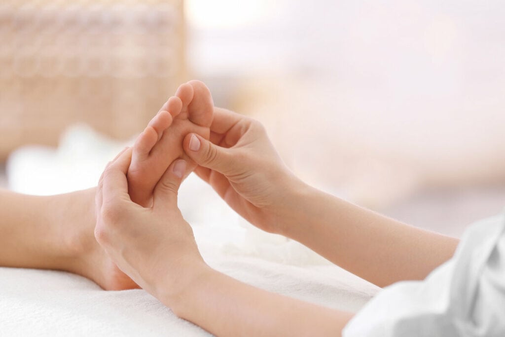 Therapeut führt traditionelle chinesische Fußmassage durch, stimuliert Reflexzonen zur Förderung des Qi-Flusses und des Wohlbefindens.